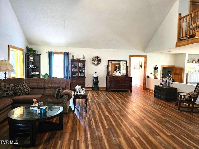 living room featuring high vaulted ceiling, a textured ceiling, and dark hardwood / wood-style flooring