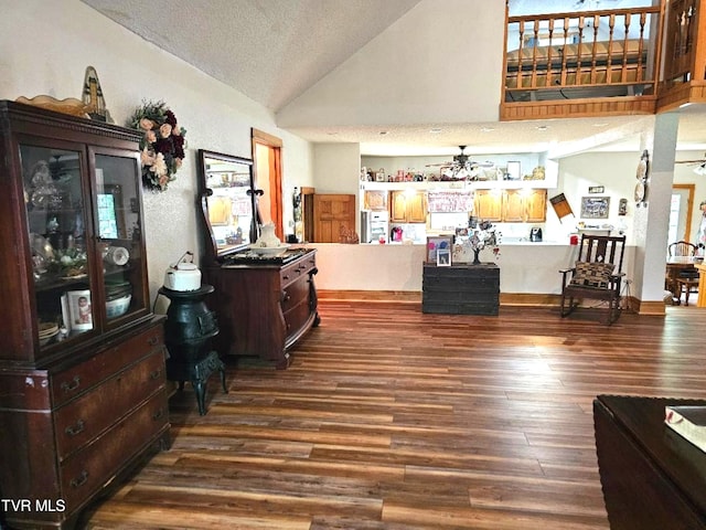 interior space with hardwood / wood-style floors, vaulted ceiling, a textured ceiling, and ceiling fan