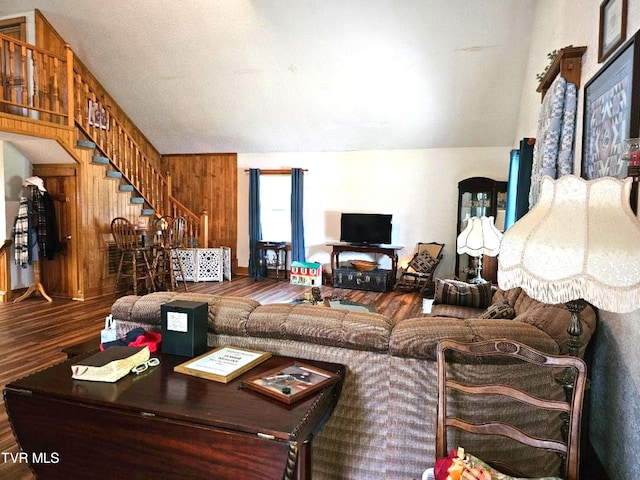 living room featuring lofted ceiling, wooden walls, and wood-type flooring