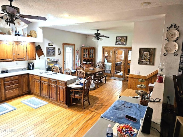 kitchen featuring light hardwood / wood-style floors, kitchen peninsula, and a textured ceiling