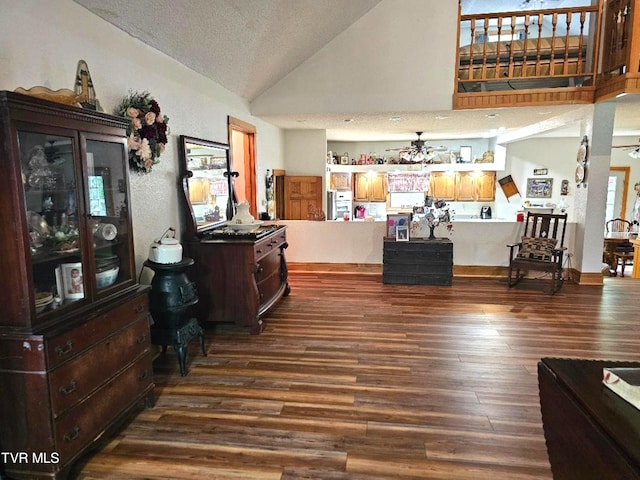 interior space with lofted ceiling, a textured ceiling, wood-type flooring, and ceiling fan