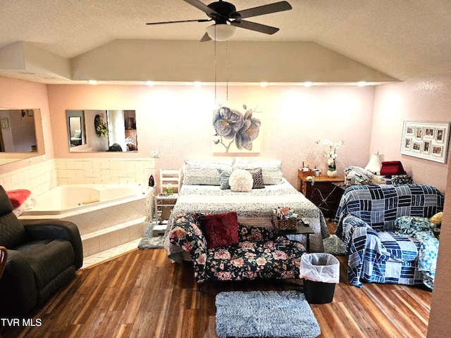 bedroom featuring lofted ceiling, hardwood / wood-style floors, a textured ceiling, and ceiling fan