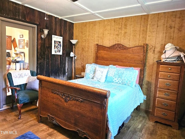 bedroom featuring wood walls and dark hardwood / wood-style floors