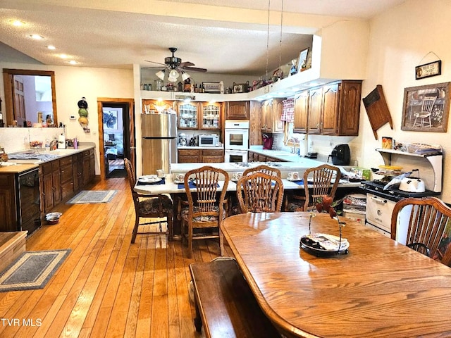 dining space featuring light hardwood / wood-style floors, a textured ceiling, sink, and ceiling fan