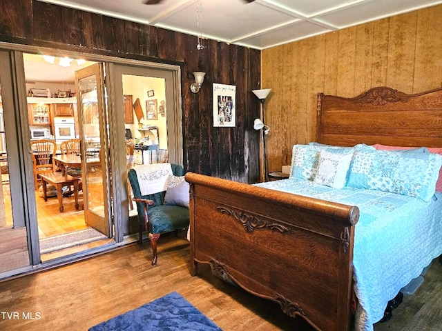 bedroom featuring hardwood / wood-style flooring and wooden walls