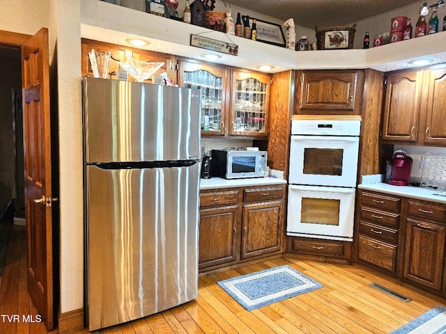 kitchen featuring light hardwood / wood-style floors and white appliances