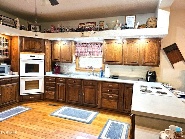 kitchen with white appliances, light hardwood / wood-style floors, and ceiling fan