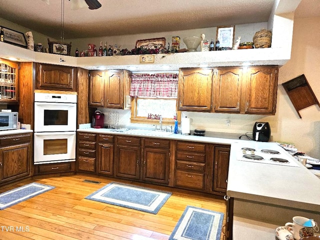 7503 Strawberry Mountain Rd, Wise, VA 24293 - kitchen with white appliances, light countertops, light wood-type flooring, and a sink