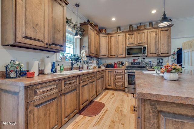 kitchen featuring light hardwood / wood-style flooring, stainless steel appliances, sink, crown molding, and decorative light fixtures