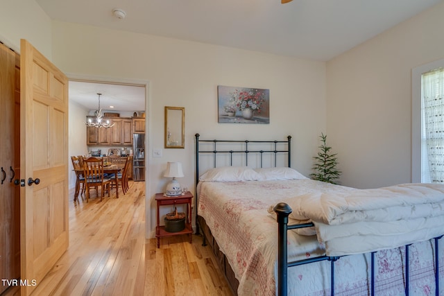 bedroom featuring light hardwood / wood-style flooring and a chandelier