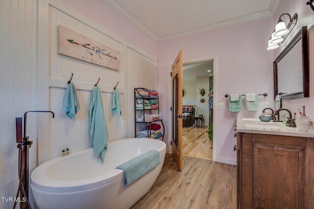 bathroom with vanity, a tub, crown molding, and wood-type flooring