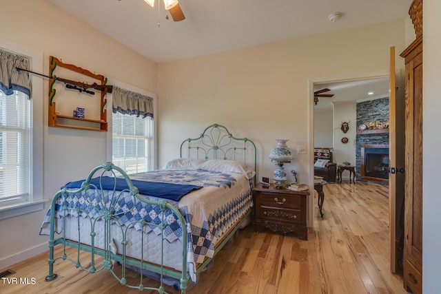 bedroom featuring ceiling fan, multiple windows, and light wood-type flooring