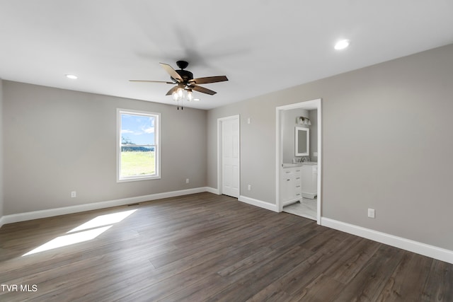 unfurnished bedroom with ensuite bathroom, sink, ceiling fan, and dark hardwood / wood-style floors