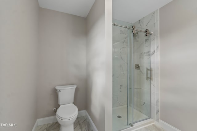 bathroom featuring toilet and a shower with door