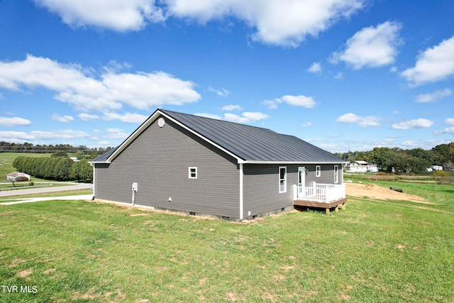 view of home's exterior featuring a rural view, a yard, and a wooden deck