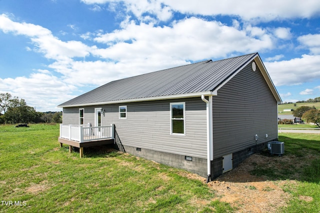 back of house with central AC unit, a lawn, and a wooden deck