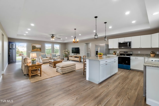 kitchen featuring ceiling fan, light hardwood / wood-style flooring, pendant lighting, white cabinets, and appliances with stainless steel finishes