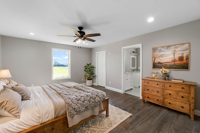 bedroom featuring ceiling fan, dark hardwood / wood-style flooring, sink, and connected bathroom