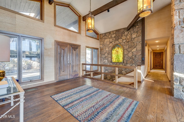 foyer featuring a healthy amount of sunlight, high vaulted ceiling, and dark hardwood / wood-style flooring