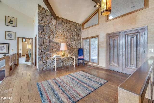 foyer entrance with high vaulted ceiling and wood-type flooring