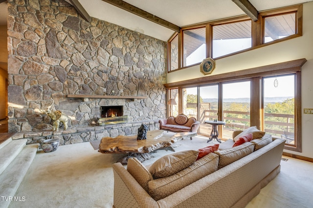 carpeted living room featuring a stone fireplace, beam ceiling, and plenty of natural light