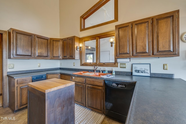 kitchen with black dishwasher, wood counters, sink, a towering ceiling, and a center island