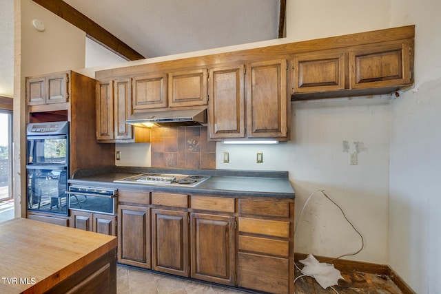 kitchen with light tile patterned flooring, backsplash, white gas cooktop, beam ceiling, and black double oven