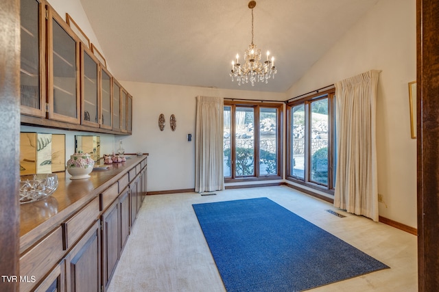 interior space featuring a chandelier, light colored carpet, and vaulted ceiling