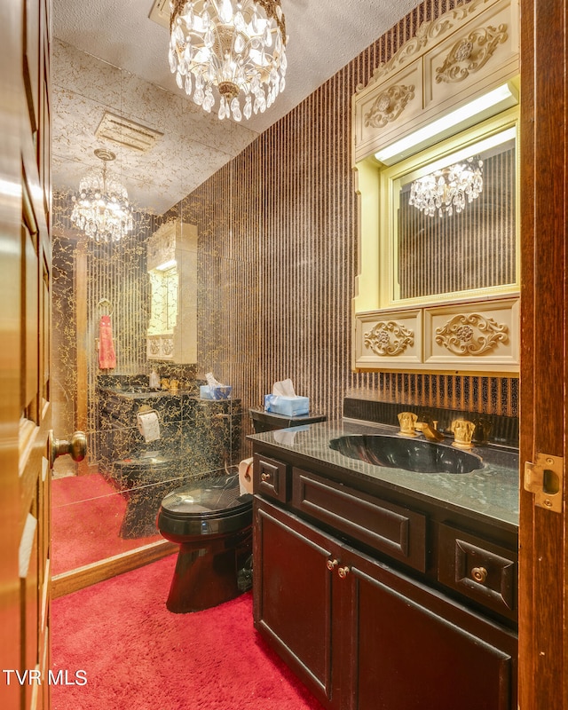 bathroom featuring toilet, an inviting chandelier, a textured ceiling, and vanity