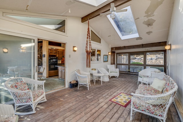 interior space with vaulted ceiling with skylight and ceiling fan