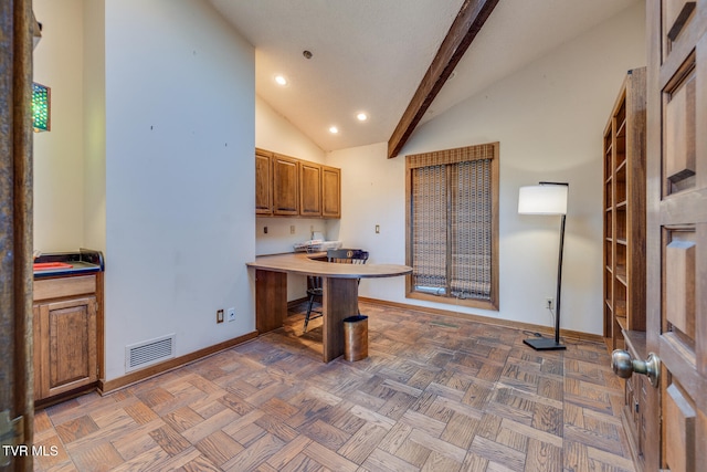 kitchen featuring parquet floors, high vaulted ceiling, beamed ceiling, and a breakfast bar