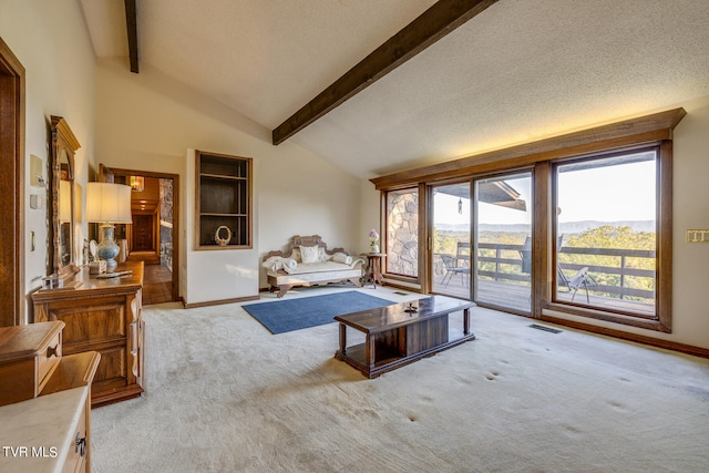 living room with light carpet, lofted ceiling with beams, a mountain view, and a textured ceiling