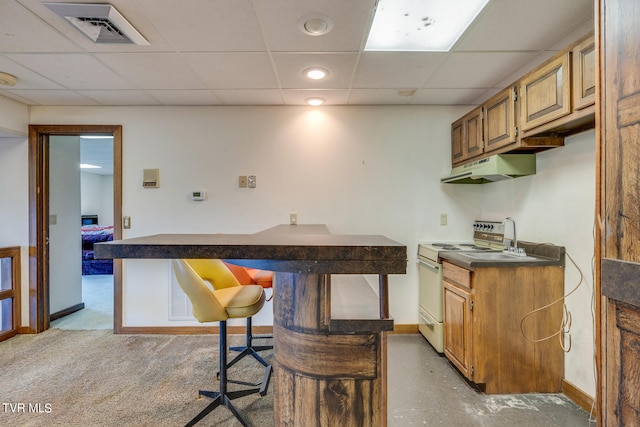 kitchen featuring a breakfast bar area, a drop ceiling, and white electric stove