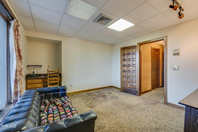 sitting room with a paneled ceiling, a healthy amount of sunlight, and light colored carpet