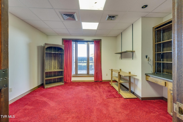 miscellaneous room with a drop ceiling and carpet flooring