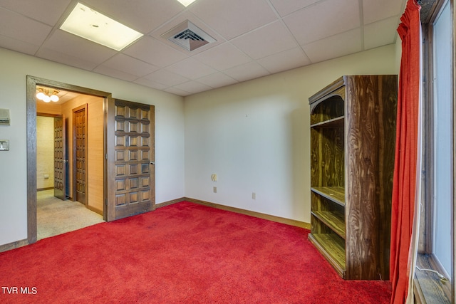 empty room with a paneled ceiling and carpet floors