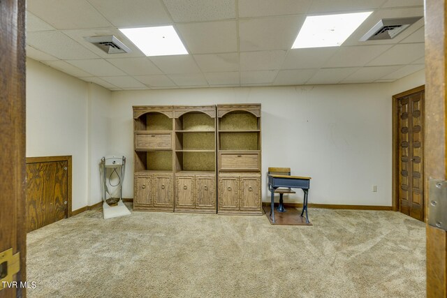 interior space featuring a paneled ceiling and carpet