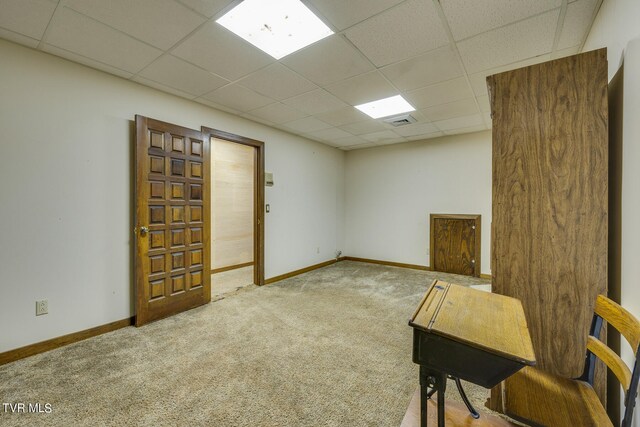 carpeted spare room with a paneled ceiling