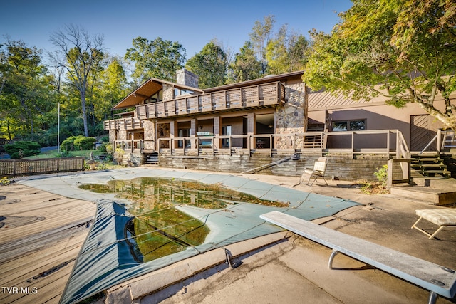 rear view of house with a patio area and a covered pool