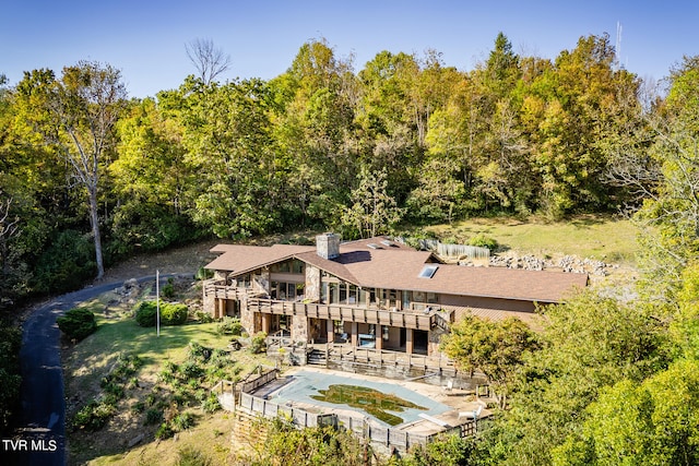 back of property with a patio area, a pool with hot tub, and a balcony