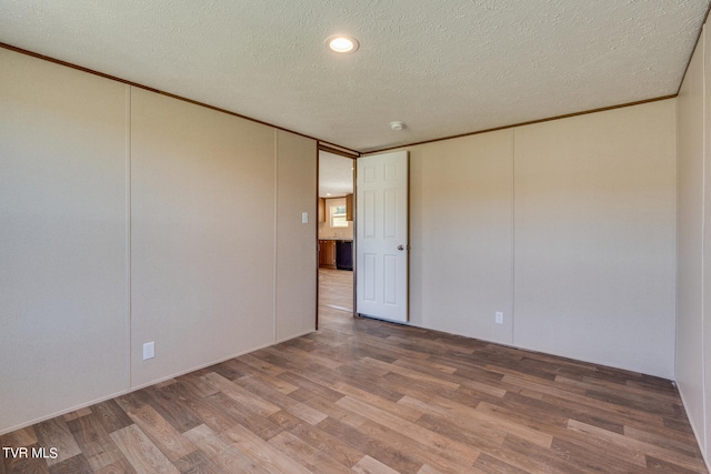 spare room featuring a textured ceiling and hardwood / wood-style floors