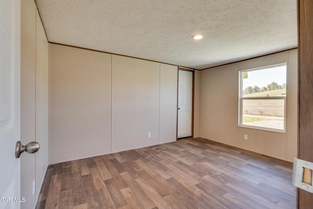 interior space featuring a textured ceiling and hardwood / wood-style flooring