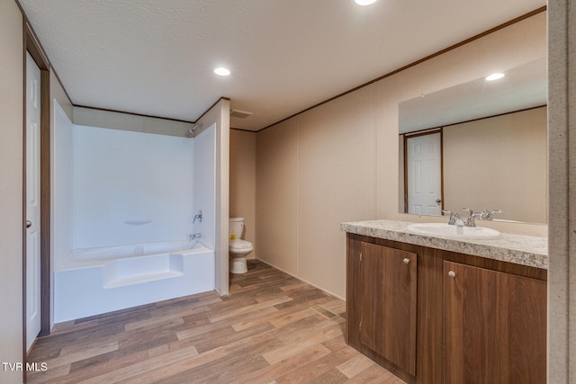 full bathroom with a textured ceiling, toilet, shower / bath combination, vanity, and hardwood / wood-style flooring