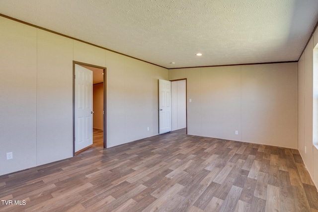 unfurnished bedroom featuring crown molding, hardwood / wood-style floors, and a textured ceiling