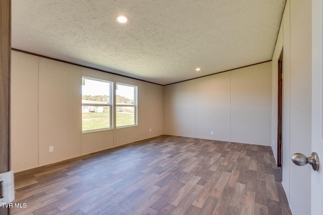 unfurnished room with a textured ceiling and hardwood / wood-style flooring