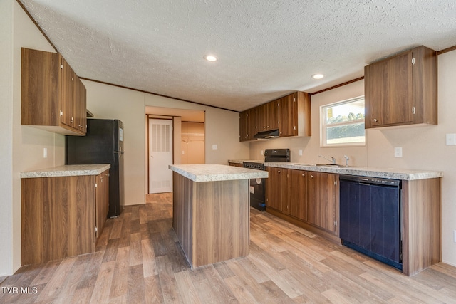 kitchen with a kitchen island, crown molding, black appliances, a textured ceiling, and light hardwood / wood-style floors