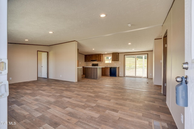 unfurnished living room featuring a textured ceiling and light wood-type flooring