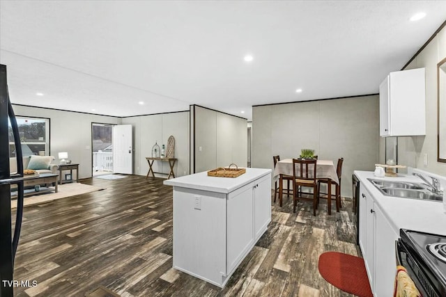 kitchen featuring a center island, sink, dark hardwood / wood-style floors, electric range oven, and white cabinetry