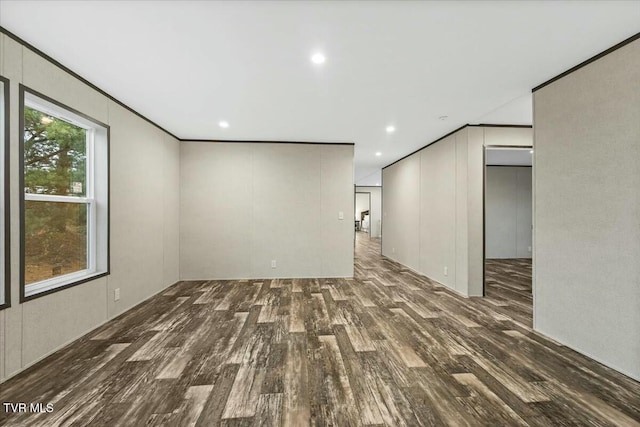 empty room with crown molding and dark wood-type flooring