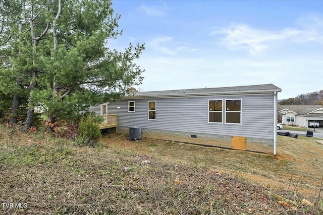 rear view of property featuring cooling unit and a wooden deck